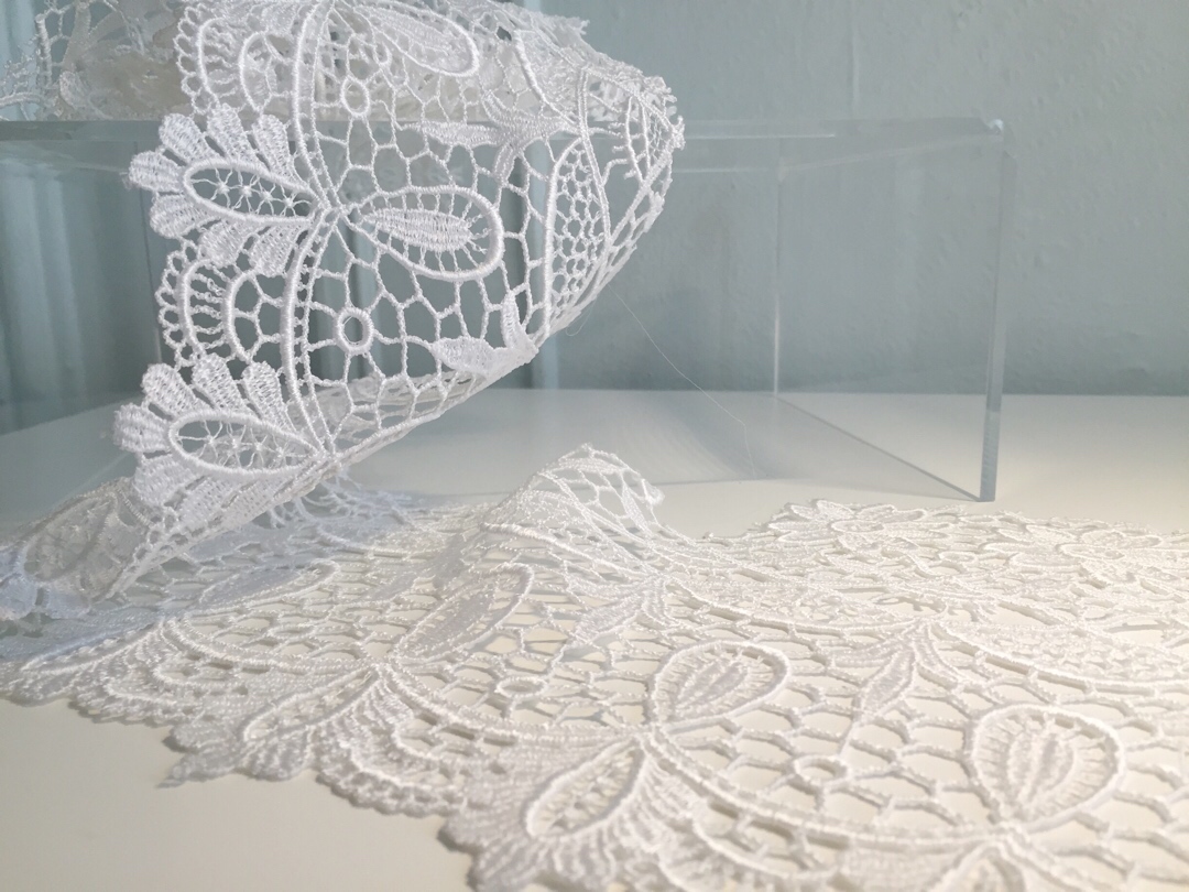 Guipure: This heavy lace is used often in edgings and insertions, but is also used all over for a bold bridal statement. It is a denser lace than most, and is good for brides who do not like the look of netting. It is distinguishable from other laces because of the legwork or "brides", which are long coarse stitches, joining the design motifs, usually flowers, as opposed to being sewn onto a mesh ground. Modern guipure can be made by embroidering the motif onto a water- or chemical-soluble material, which is dissolved away after later. I particularly love it as a lace jacket or crop top over a simple dress. 