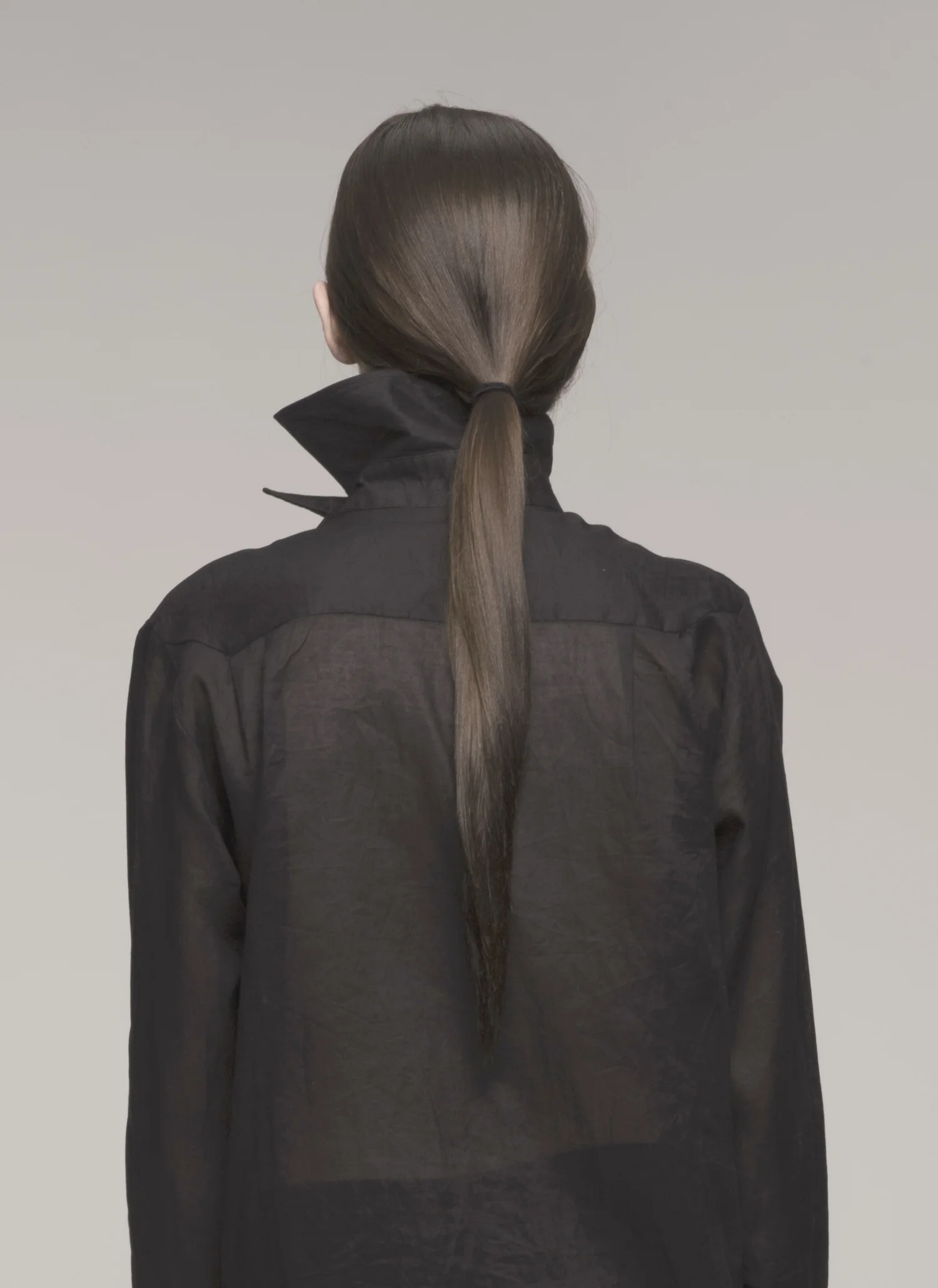 model in sheer black shirt, back to camera
