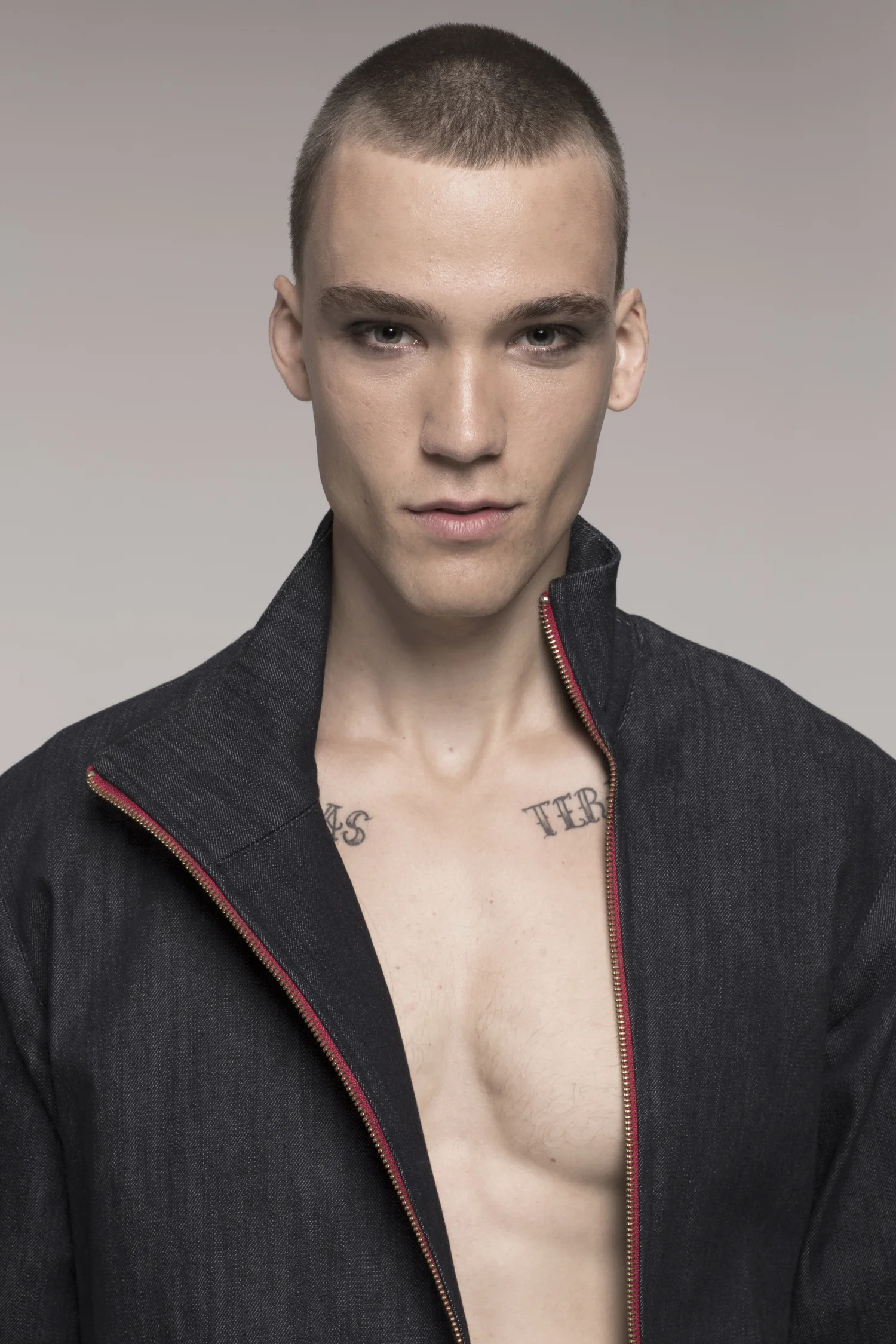 male model in denim pants suit, close up, tattooed chest exposed