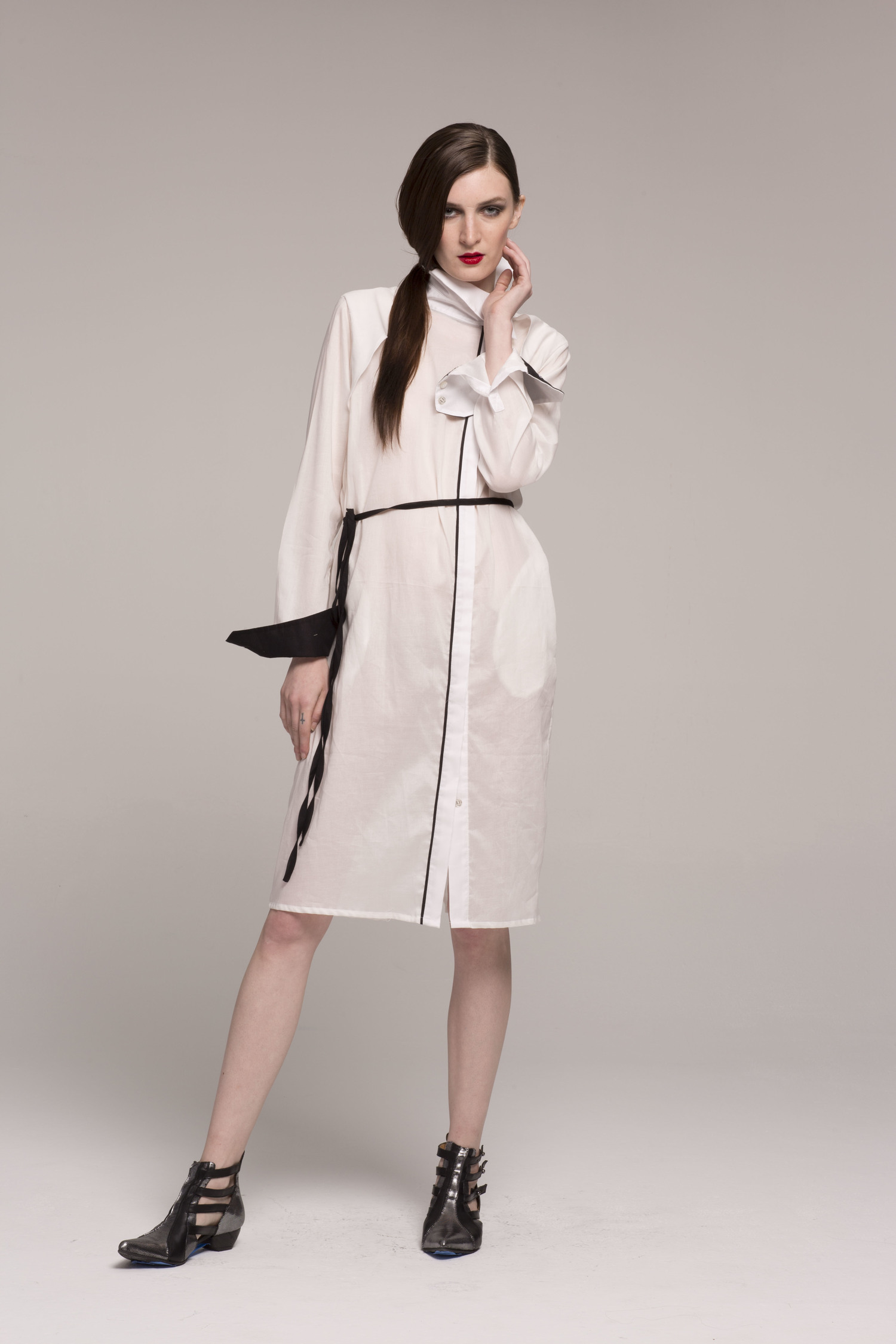 model in sheer white collared dress with black stripe down center, black cuffs