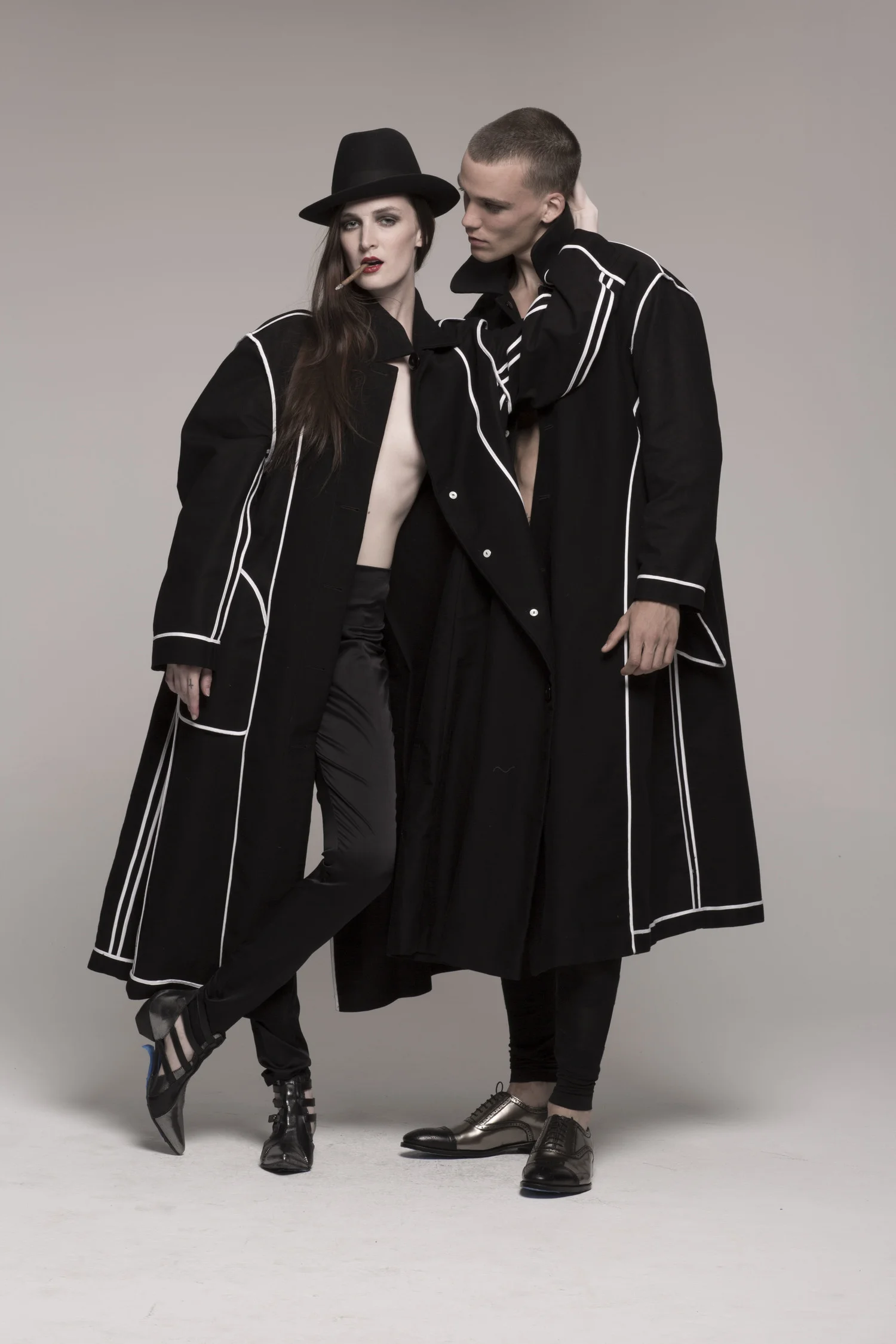 Two models wearing long black coats, inside out, Coco and Cocotte’s Cotton Coat is made-to-order and handcrafted by Marine at her atelier in Hudson, New York.