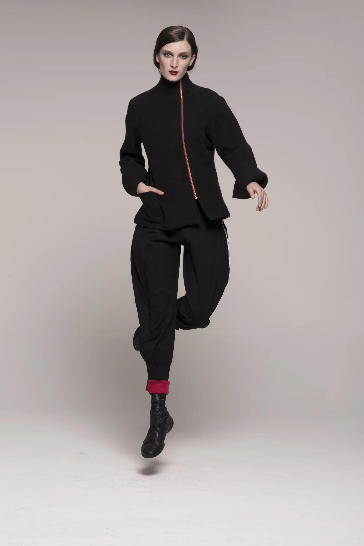 model in black SECOND SKIN jacket, red stripe down center, jumping