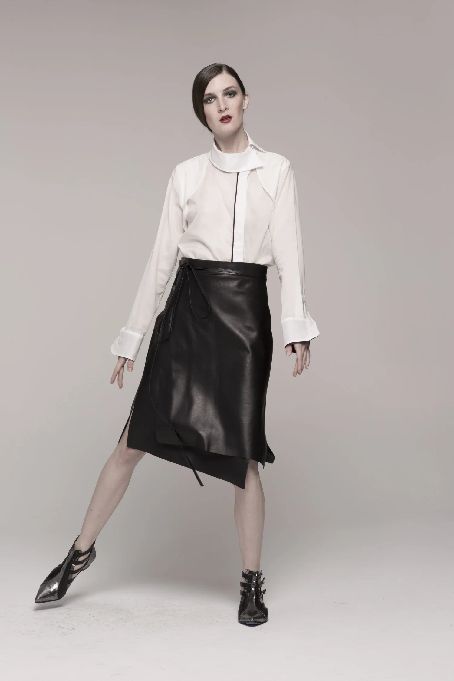 model in black leather wrap skin skirt, white long-sleeved shirt