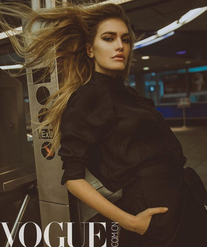 model leaning against NYC subway post in black shirt by Marine Penvern, Vogue magazine