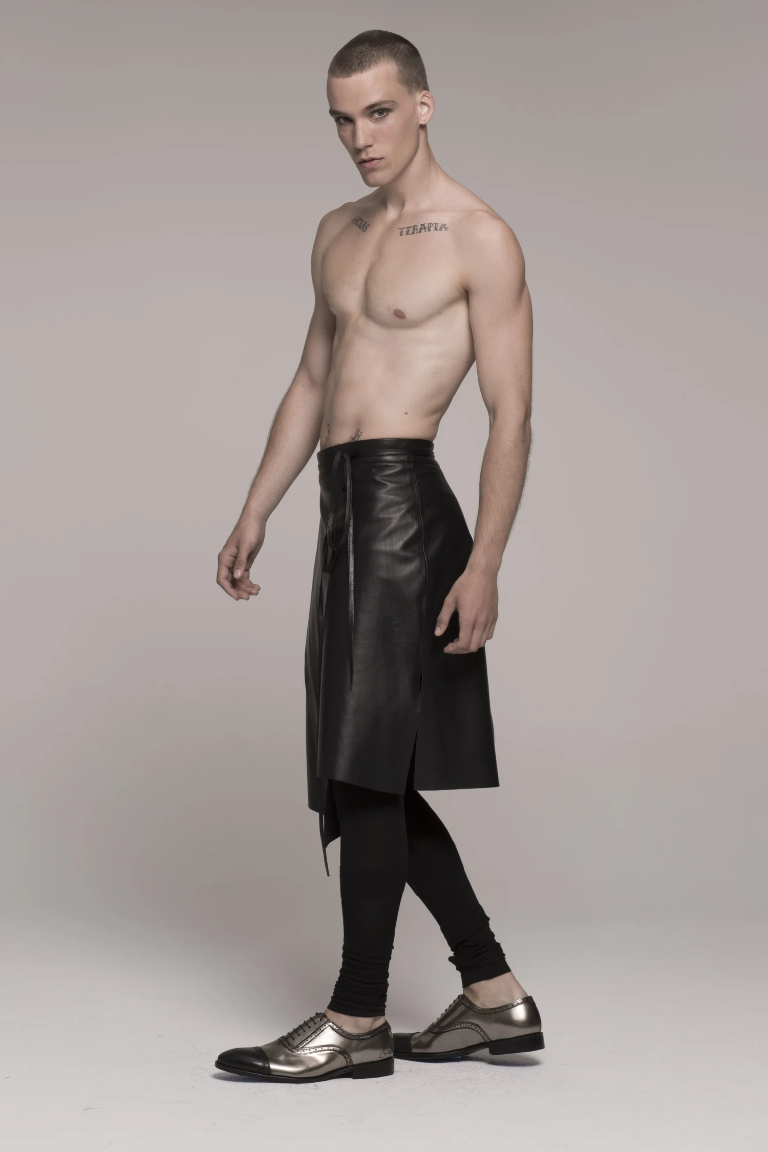 male model in black leather wrap skin skirt, bear-chested
