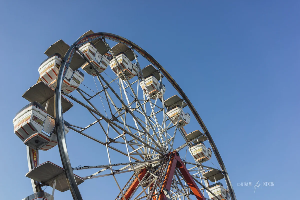 Ferris wheel against a blue sly at a carnival