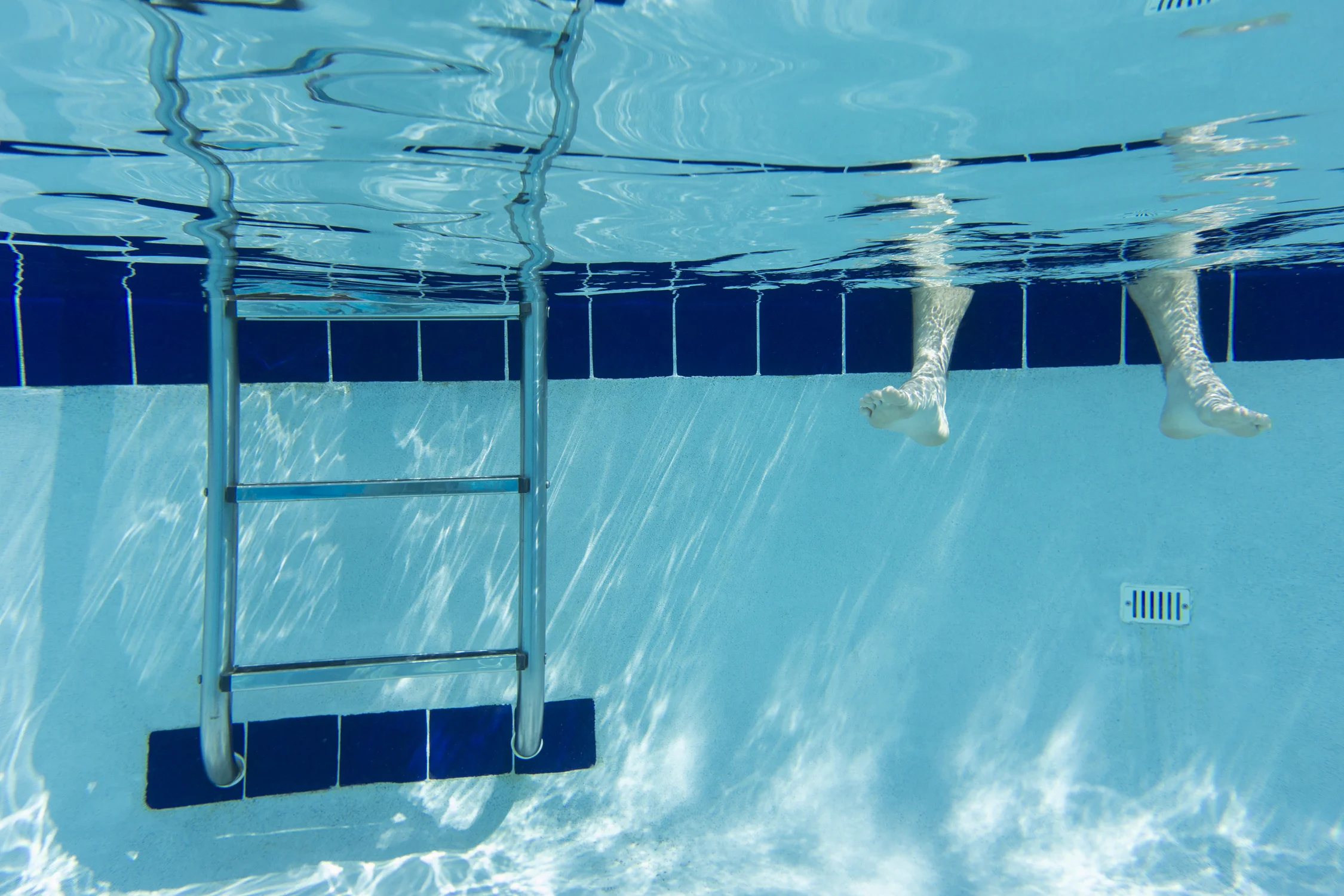 A pair of feet in a swimmimg pool