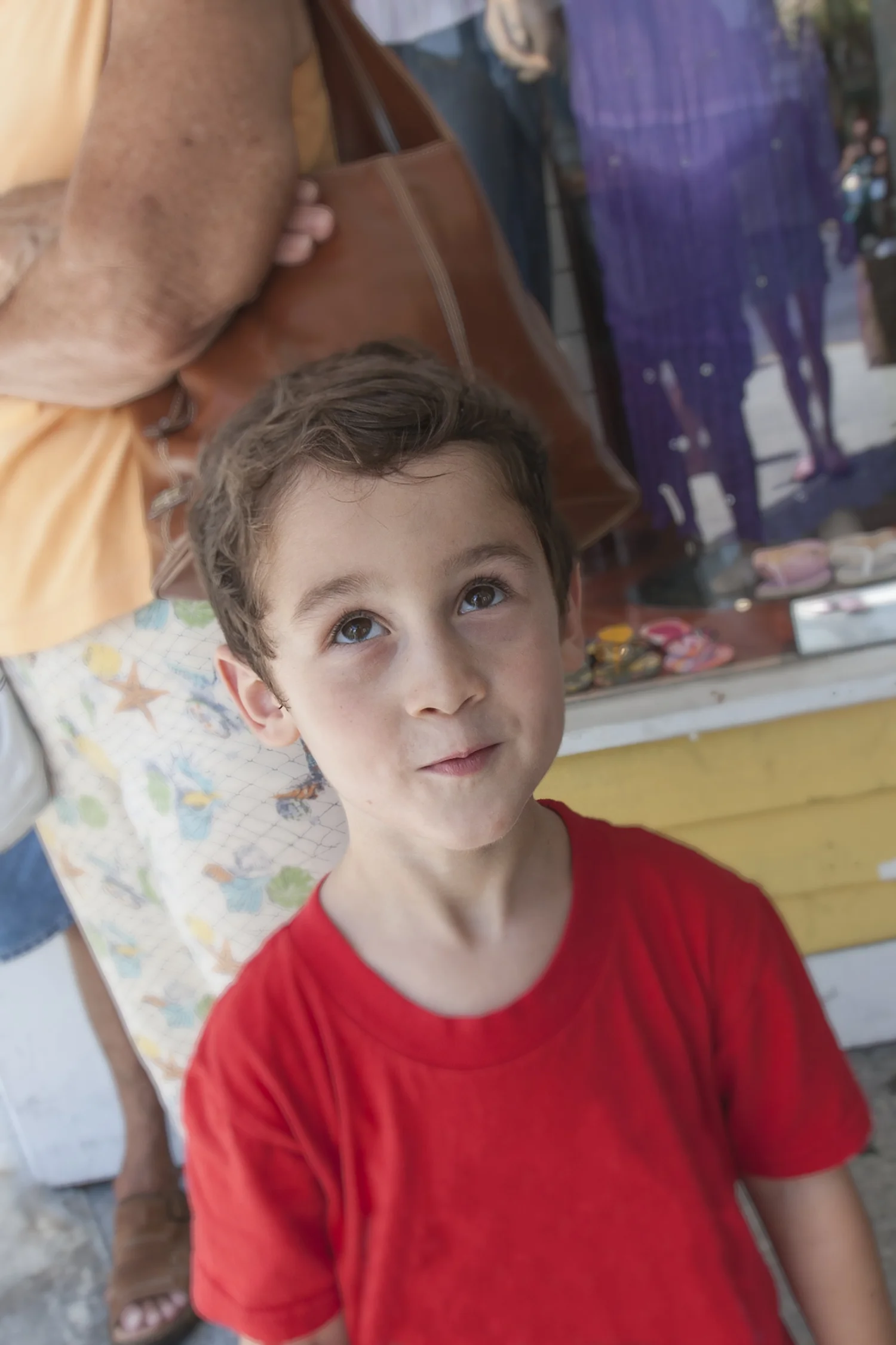 Toddler boy looking up with a smirk on his face