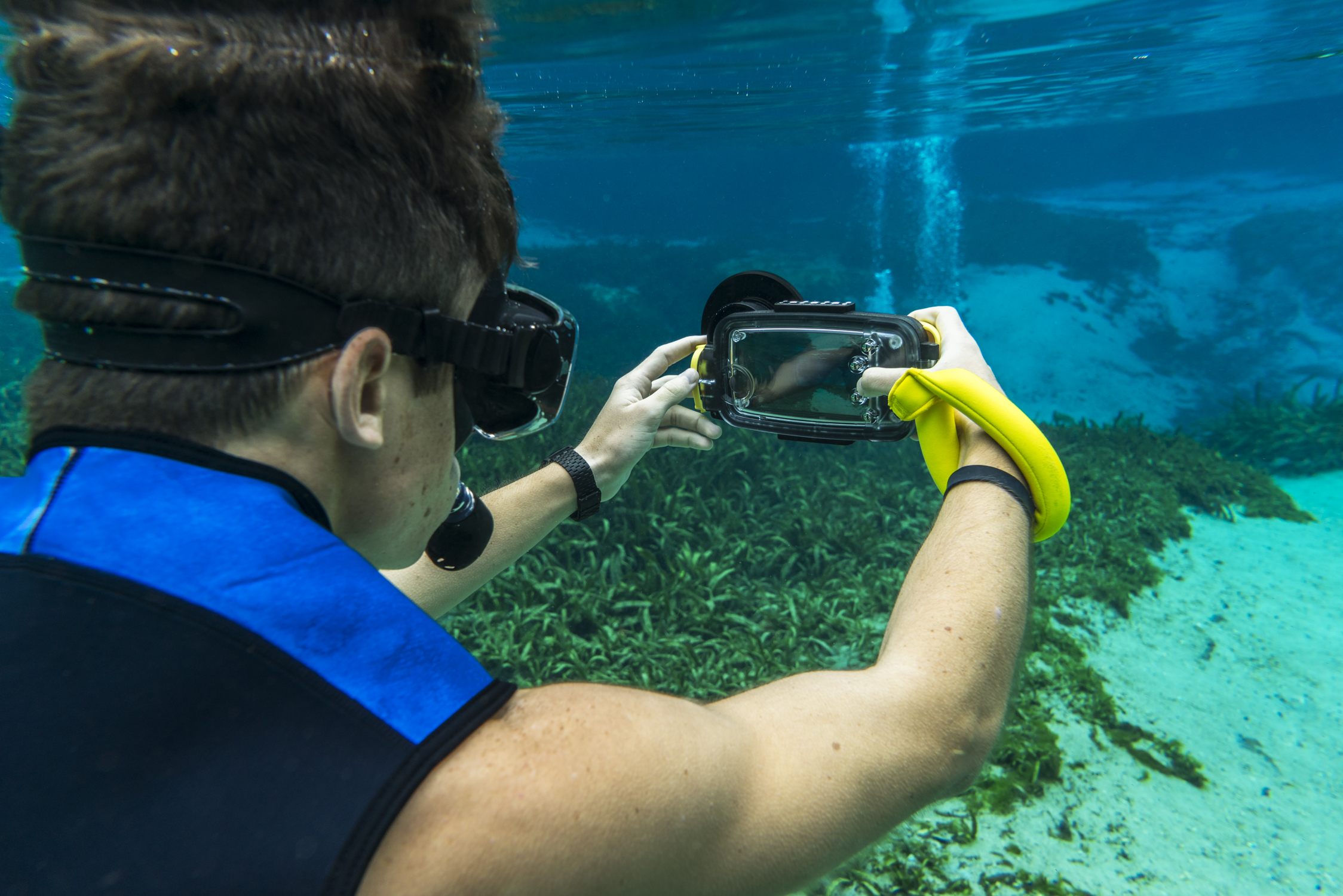 A snorkeler using a smartphone camera underwater