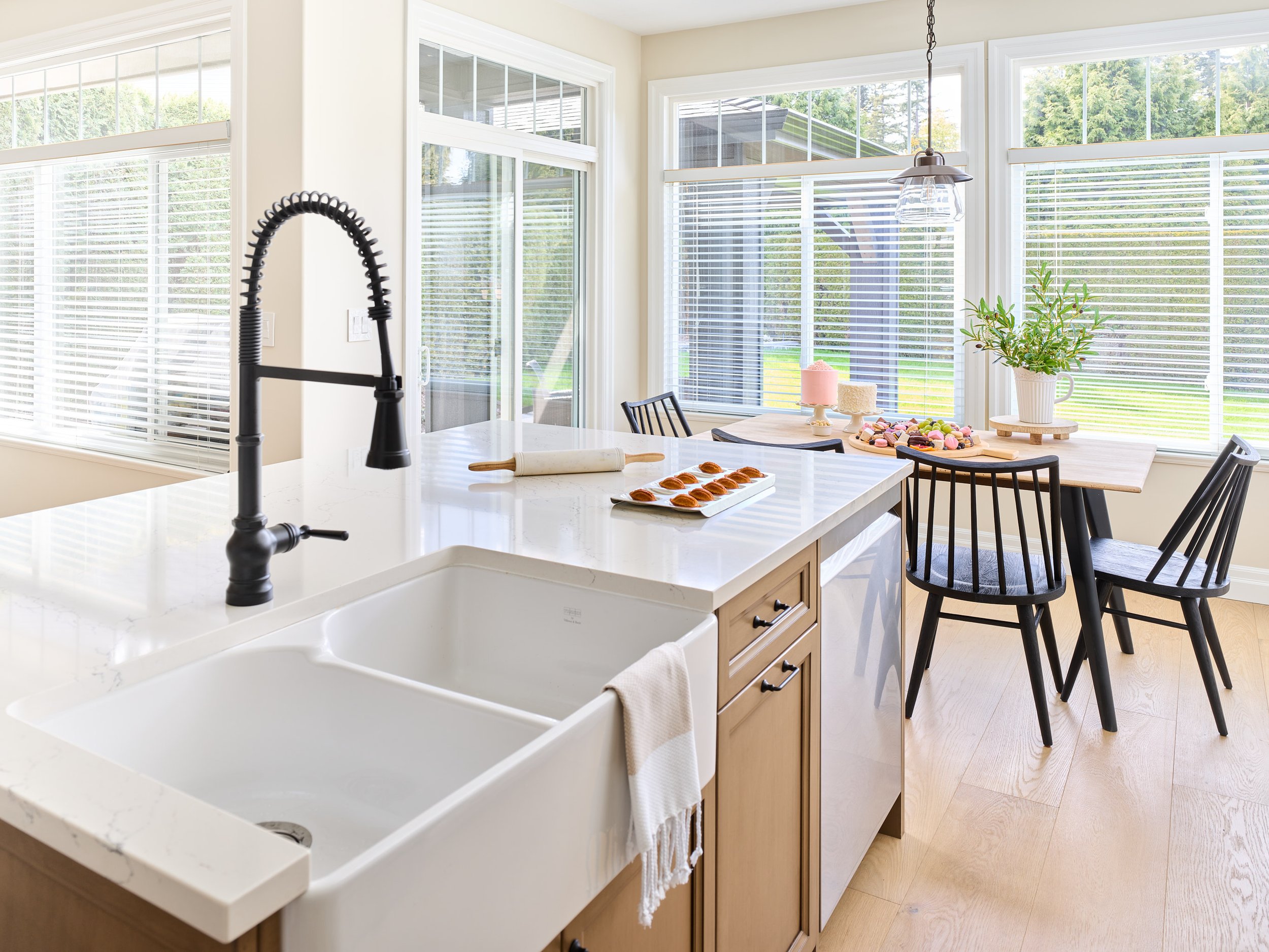 Apron-front double-bowl porcelain sink and lightly veined quartz counter make for a beautiful workspace.