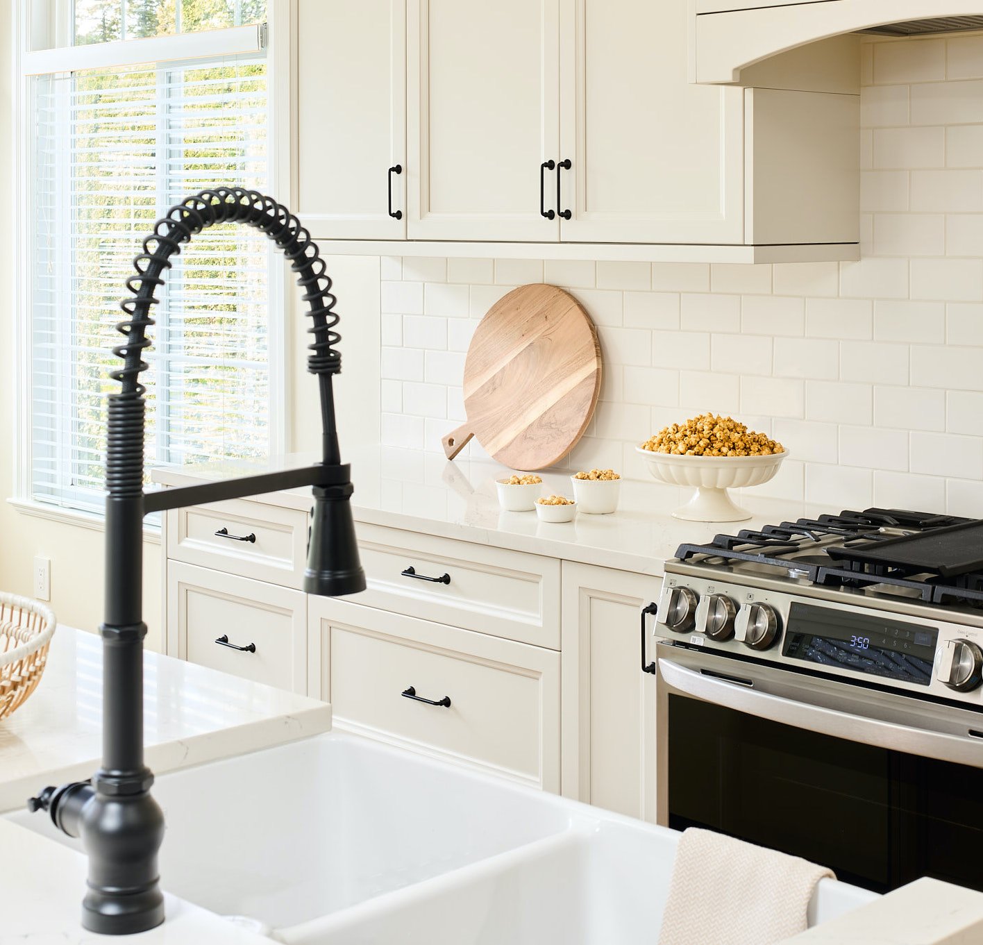 Black gooseneck faucet and black cabinet pulls reinforce the modern farmhouse vibe.