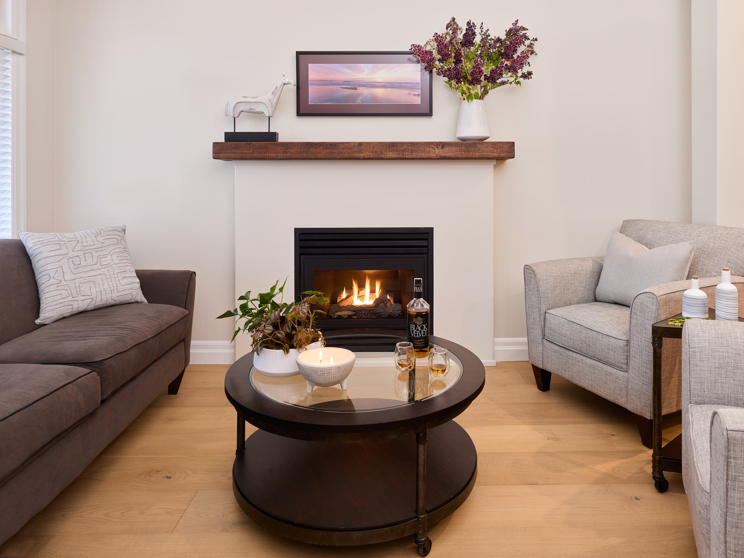 The traditional fireplace mantle and dated tile surround were replaced with a rustic beam shelf for a pared-down look.