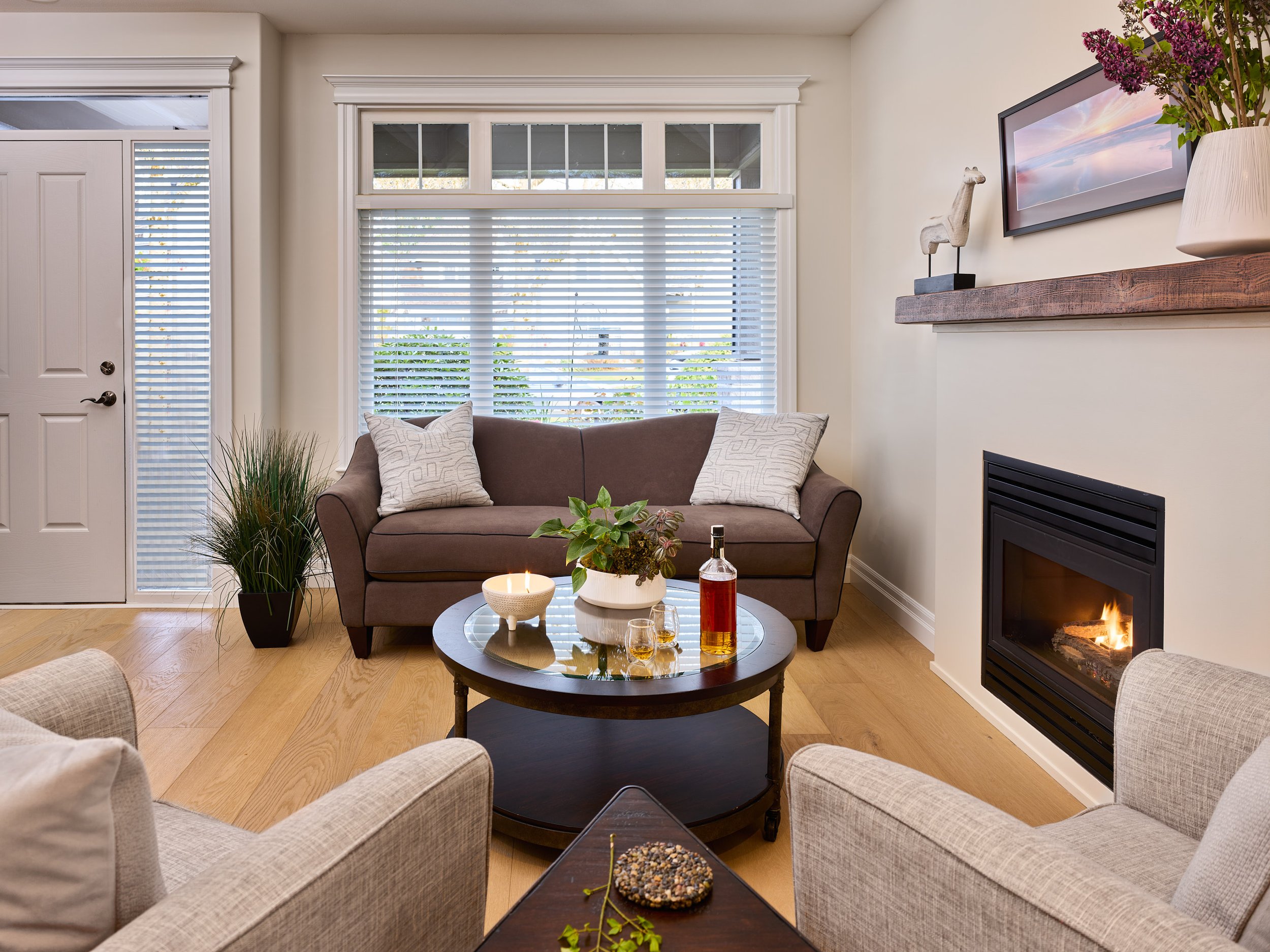 New wide plank white oak flooring was laid throughout the main floor replacing dated tile, wood, and wall-to-wall carpeting for a cohesive look.
