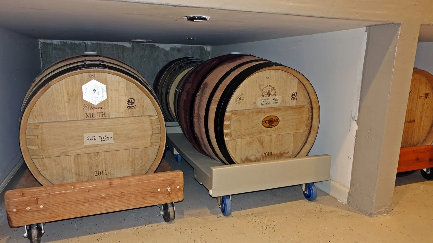 Barrels of the 2010 and 2011 vintages resting on their racks in the cellar