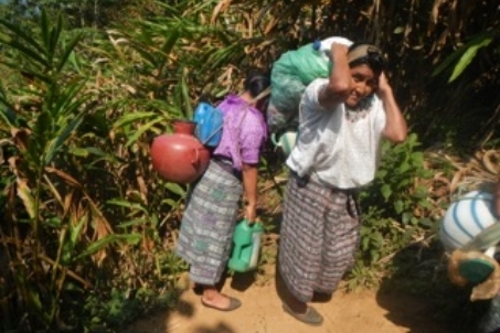 Villagers trekking back up the mountain with water from the spring