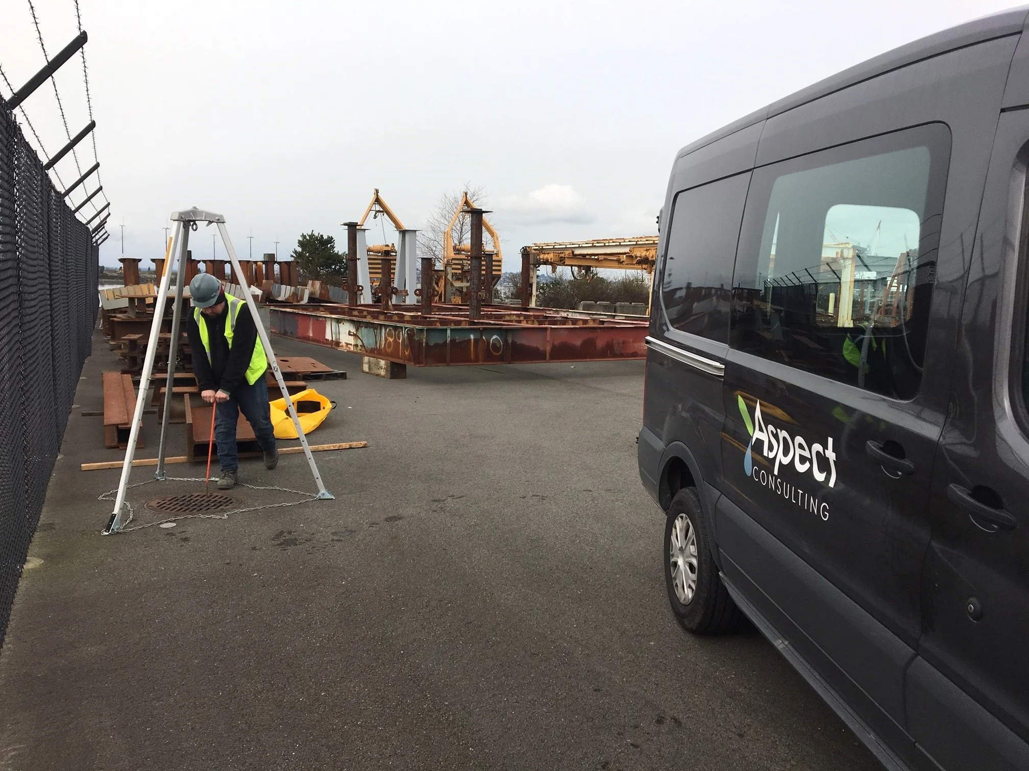 Aspect personnel collecting a sediment sample at an industrial site.
