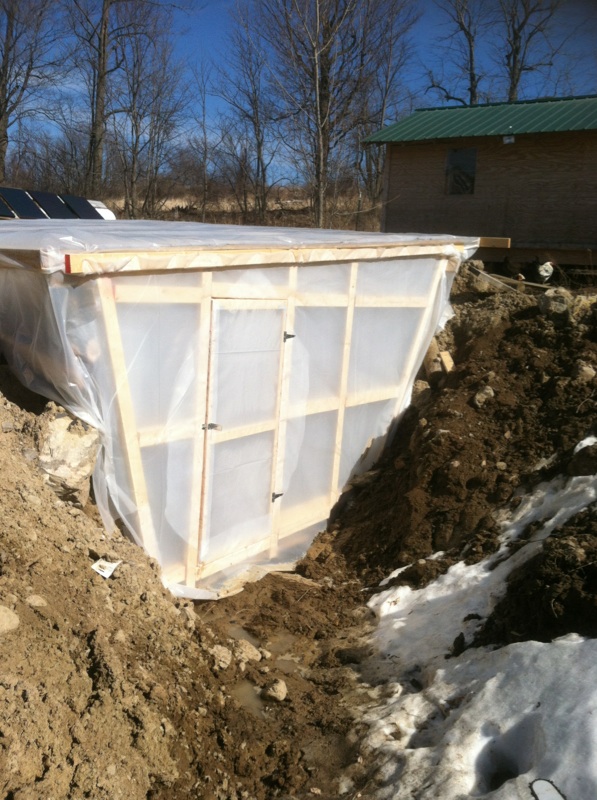 Here is our new greenhouse! It is built into the side of the hill in front of the chicken coop. By building half underground we are able to take advantage of the insulating powers of the ground which means less supplemental heat is needed compared to a traditional greenhouse. Also, the ground should help keep it cooler in the heat of summer than a traditional greenhouse would be. 