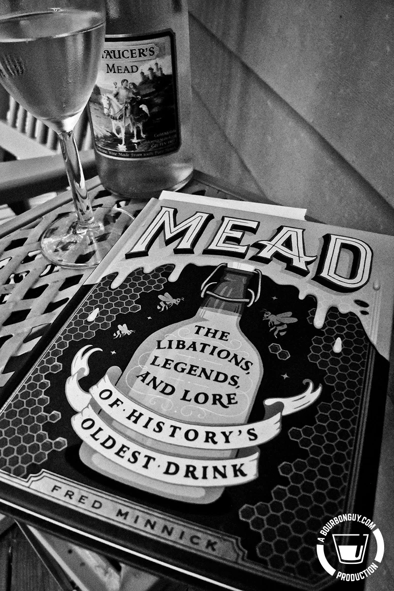 IMAGE: The book Mead: The Libations, Legends, and Lore of History's Oldest Drink by Fred Minnick laying on a table by a glass of mead and a partially filled bottle of mead.