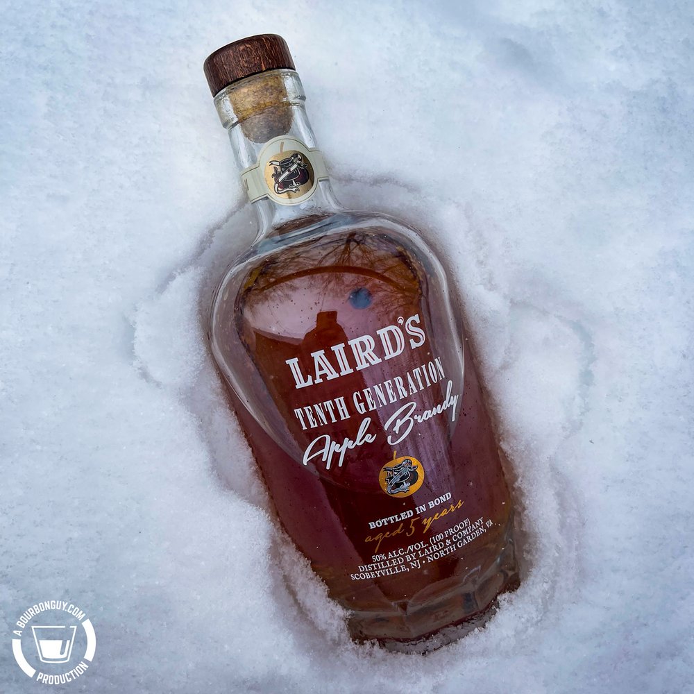 IMAGE: A Bottle of Laird's 10th Generation Apple Brandy laying in a snow bank.