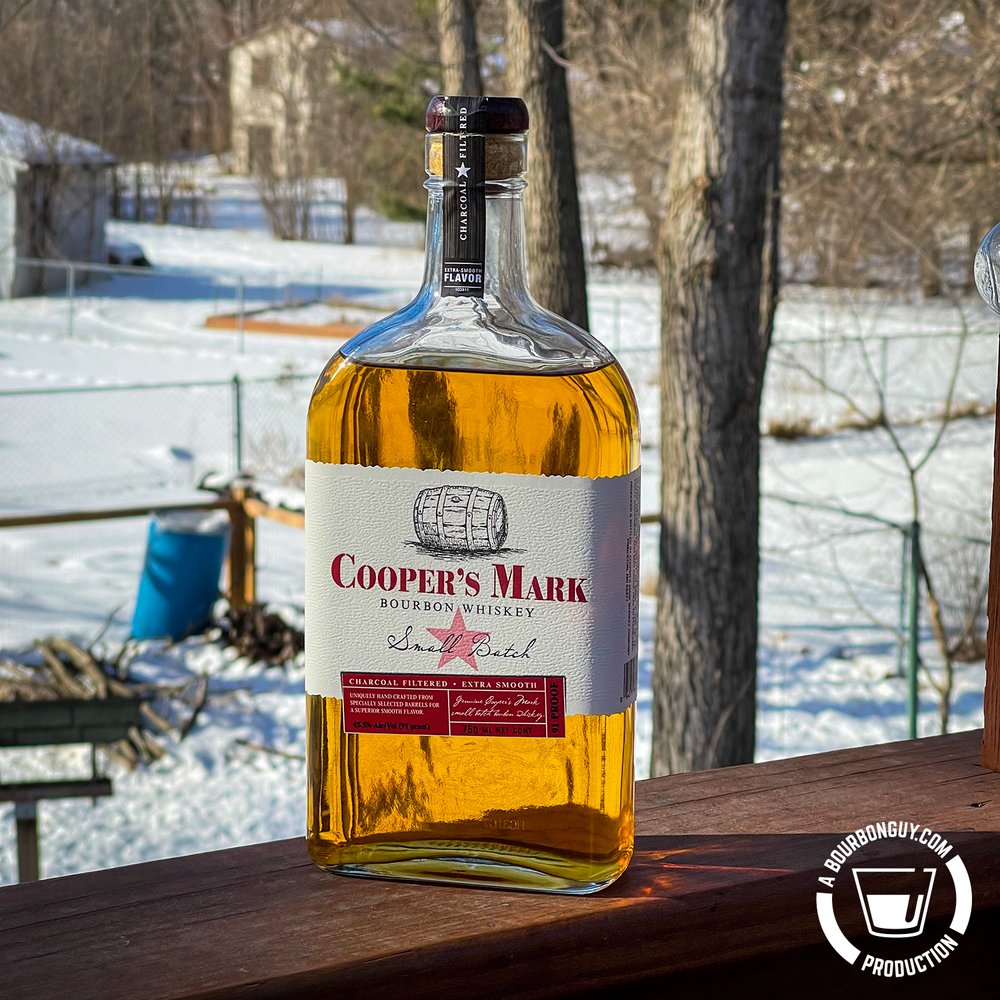 An image of Cooper's Mark Small Batch Bourbon sitting on a railing.