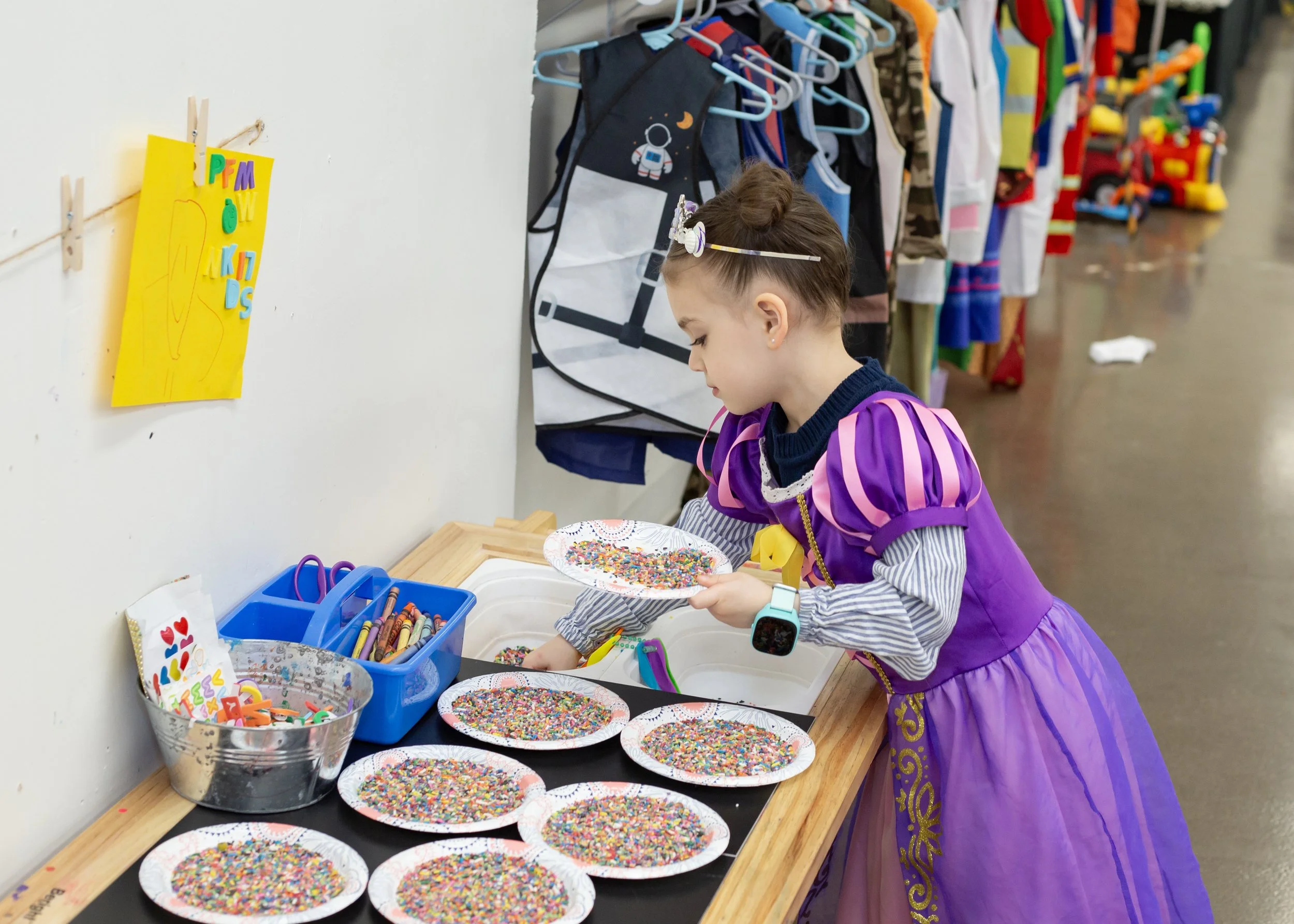 A child plays in a sensory bin inside this mesa arizona playspace and community space for parents
