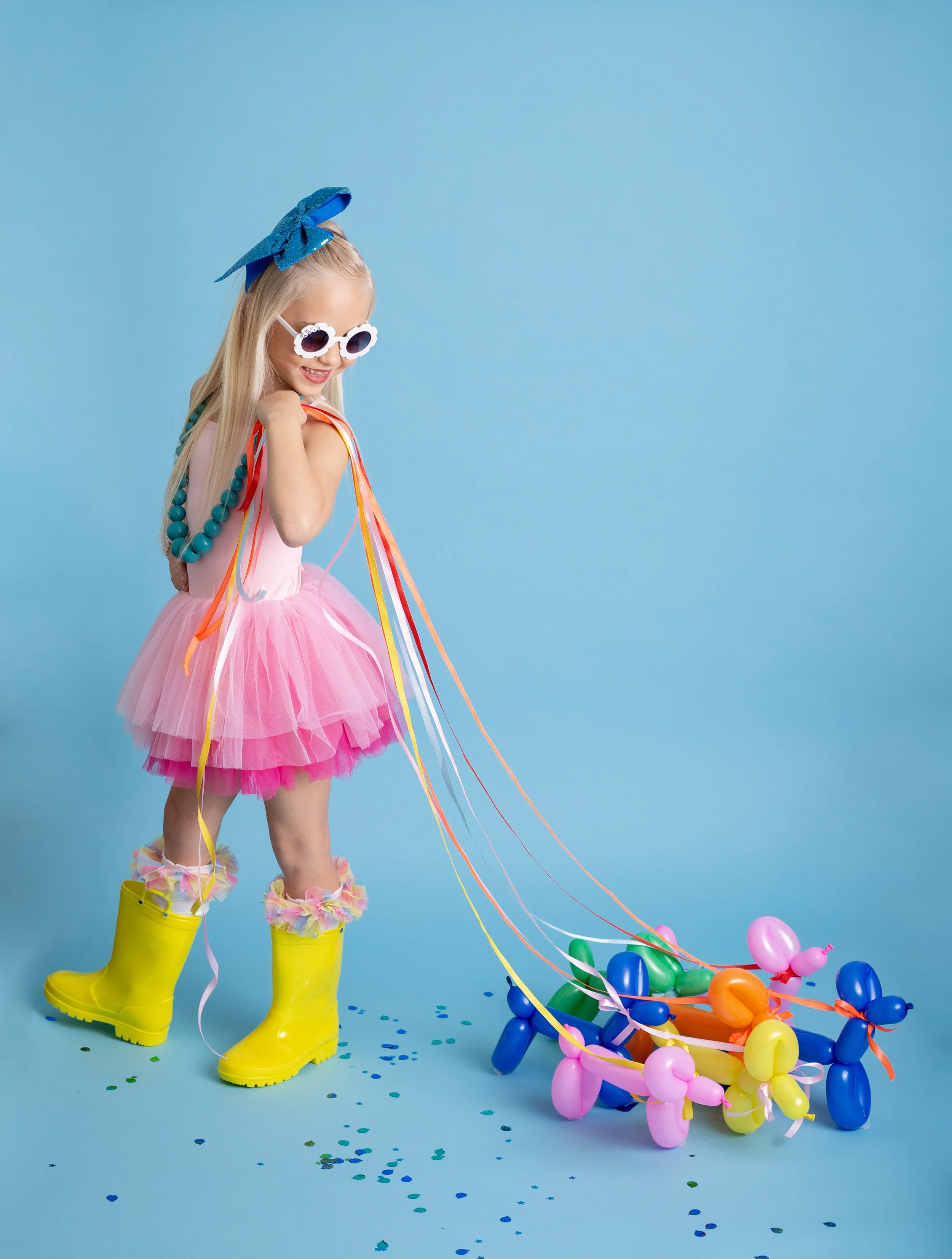 Happy child enjoying a colorful birthday session with a balloon dog in a Gilbert, Arizona photography studio.