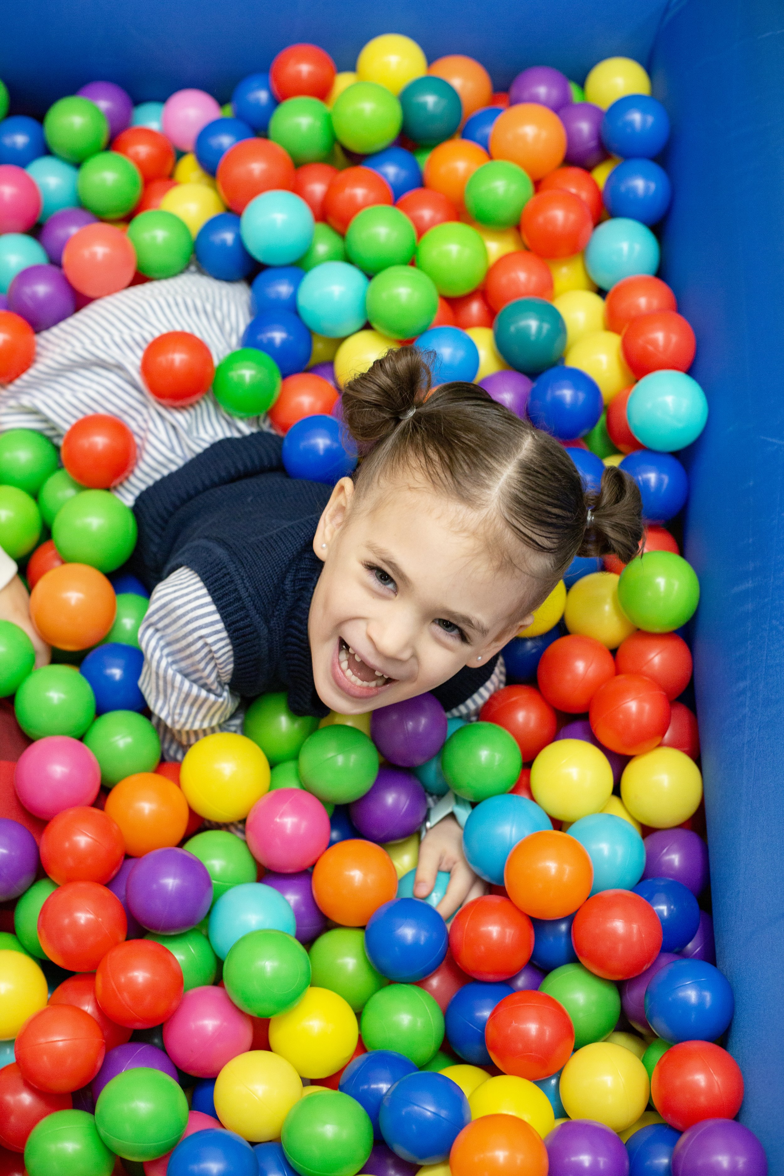 A child plays in a ball pit inside this mesa arizona playspace and community space for parents