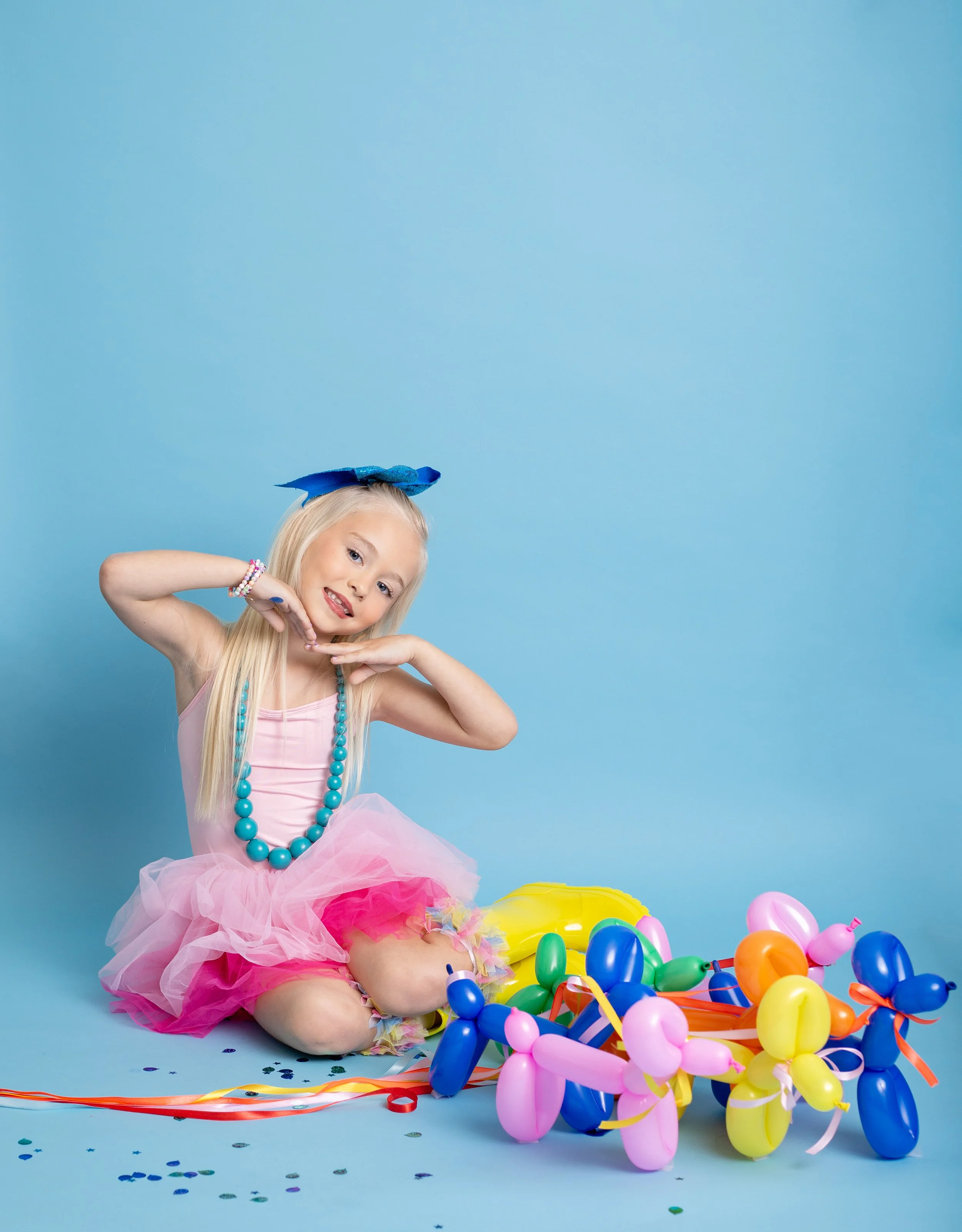 Happy child enjoying a colorful birthday session with a balloon dog in a Gilbert, Arizona photography studio.