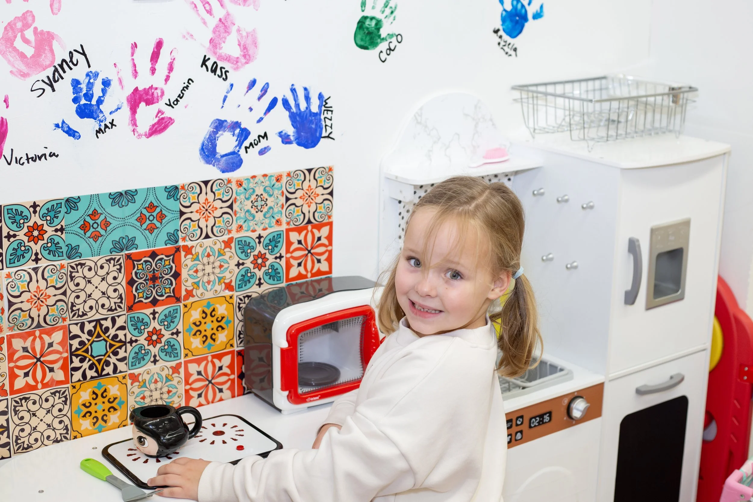 A child plays kitchen inside this mesa arizona playspace and community space for parents