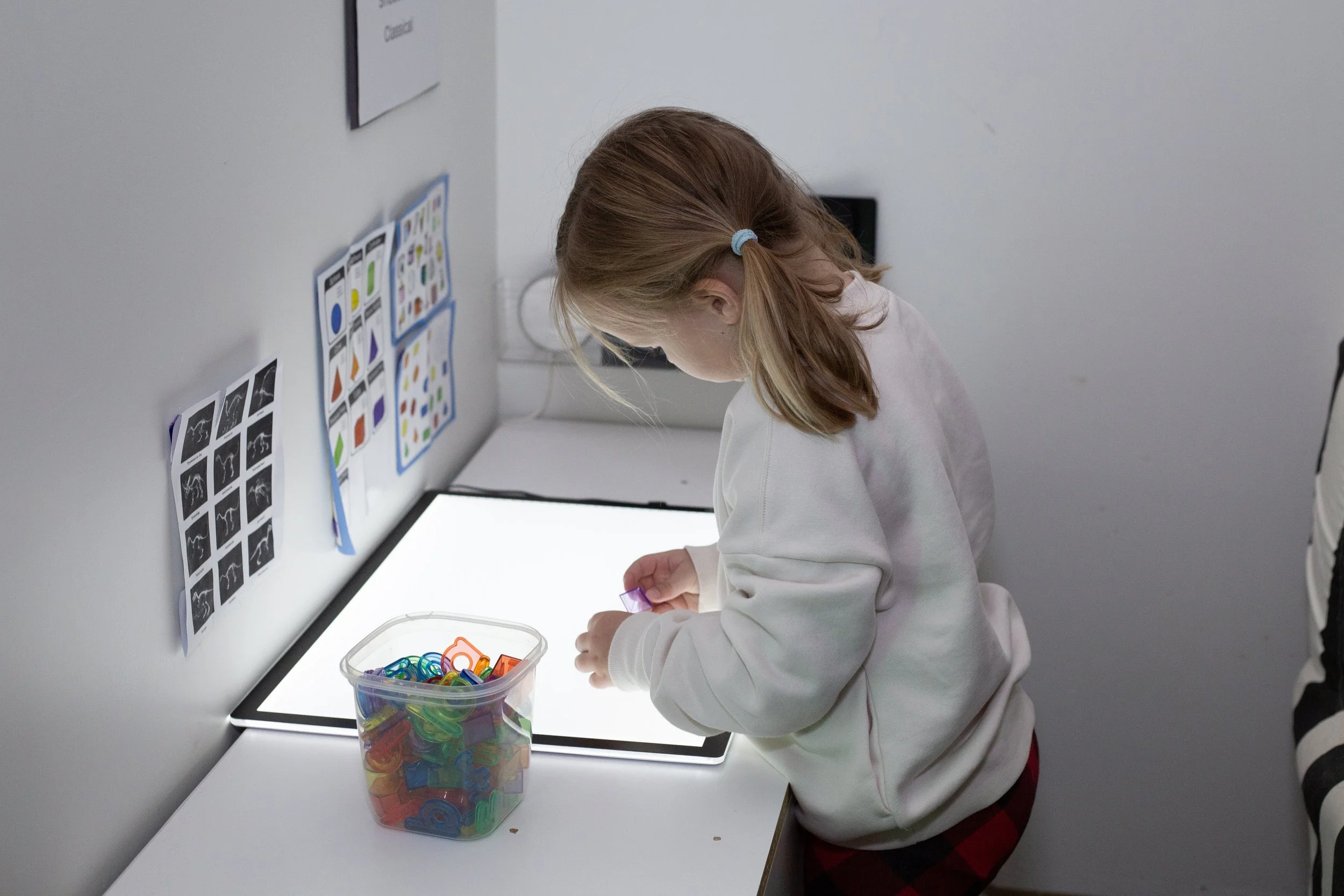 A child plays in a quiet sensory room nside this mesa arizona playspace and community space for parents