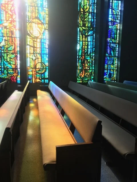  The bright colors of the stained glass windows shine onto the carpet.
