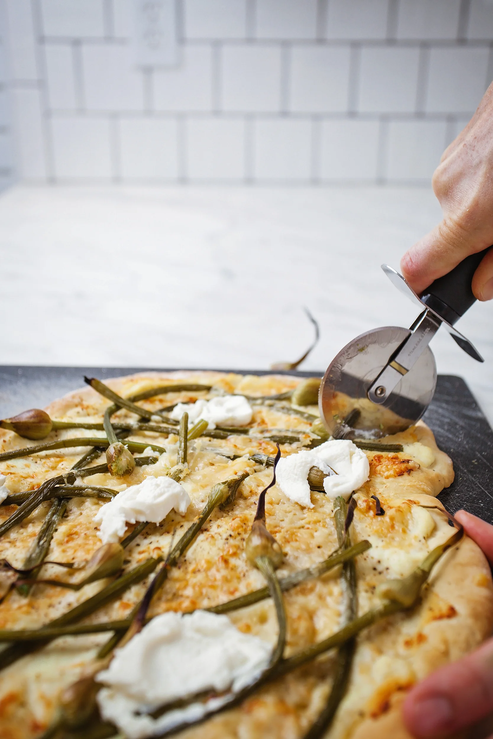 Garlic scape white pizza with ricotta cheese, shredded Gruyere cheese and grated Parmesan cheese!
