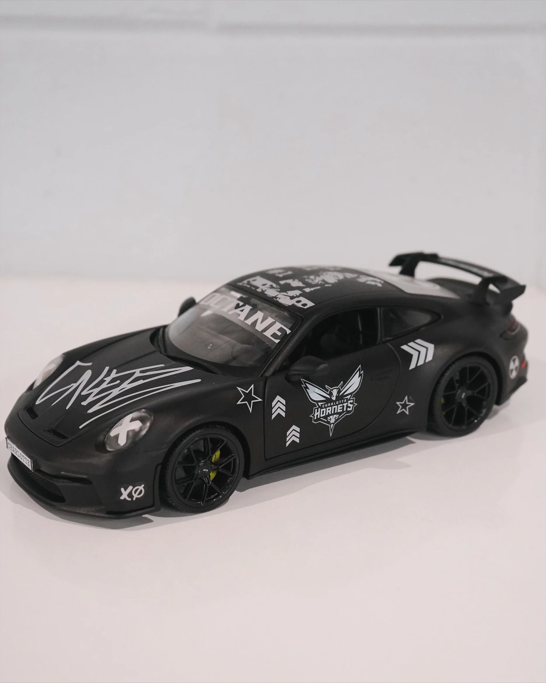 Custom matte black Porsche 911 GT3 designed by Charlotte artist Kyle Mosher for Don Toliver and the Charlotte Hornets featuring Octane album-inspired graphics.