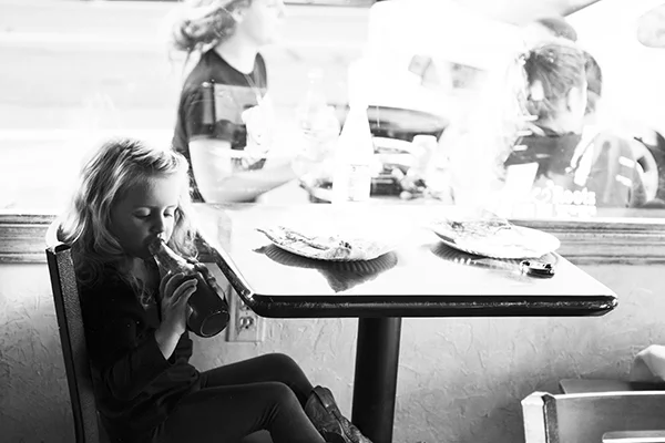 a little girl in a pizza shop