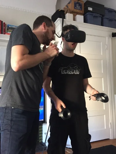 Clint showing Zack the basics of VR.