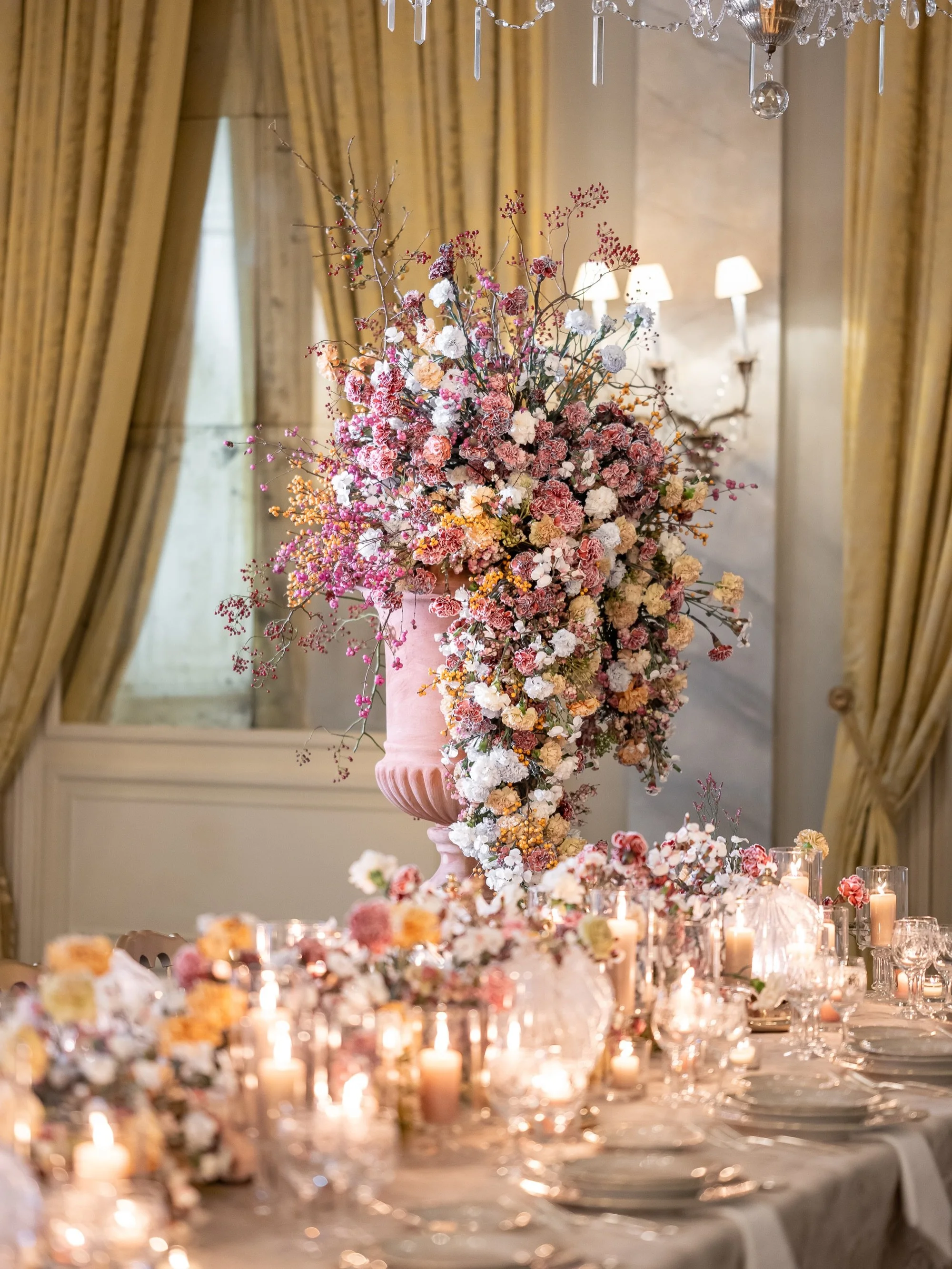 A dinner table fit for a king &amp; queen! 
For Alana and Philip&rsquo;s dinner reception we designed a large scale urn filled with specialty carnations and autumnal branches cascading onto the center of a 19-meter long table. Custom tablecloth, embr