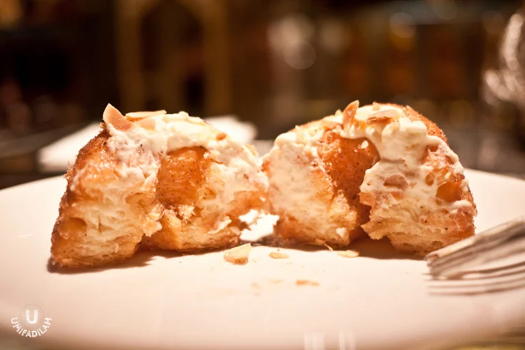 Kronut being cut in half, but not by a serrated knife as per Dominique Ansel's guide , so it might not look as good as the advertised cronuts photo on the internet , but yes I can see the delicate croissant layers filled with cream. OMG DROOLING.