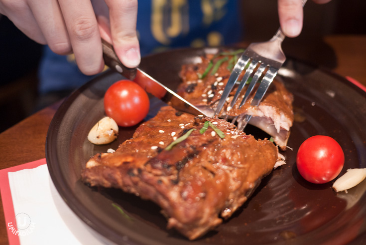 A friend of
mine, cutting through the 7-rack of
Koushi No Ribu (Grilled Baby Back Ribs – IDR 150.000).