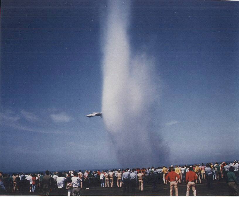    Either an F-14 nearing the speed of sound with the biggest vapor cone of all time or an F-14 demonstrating travel through folded space and time.   