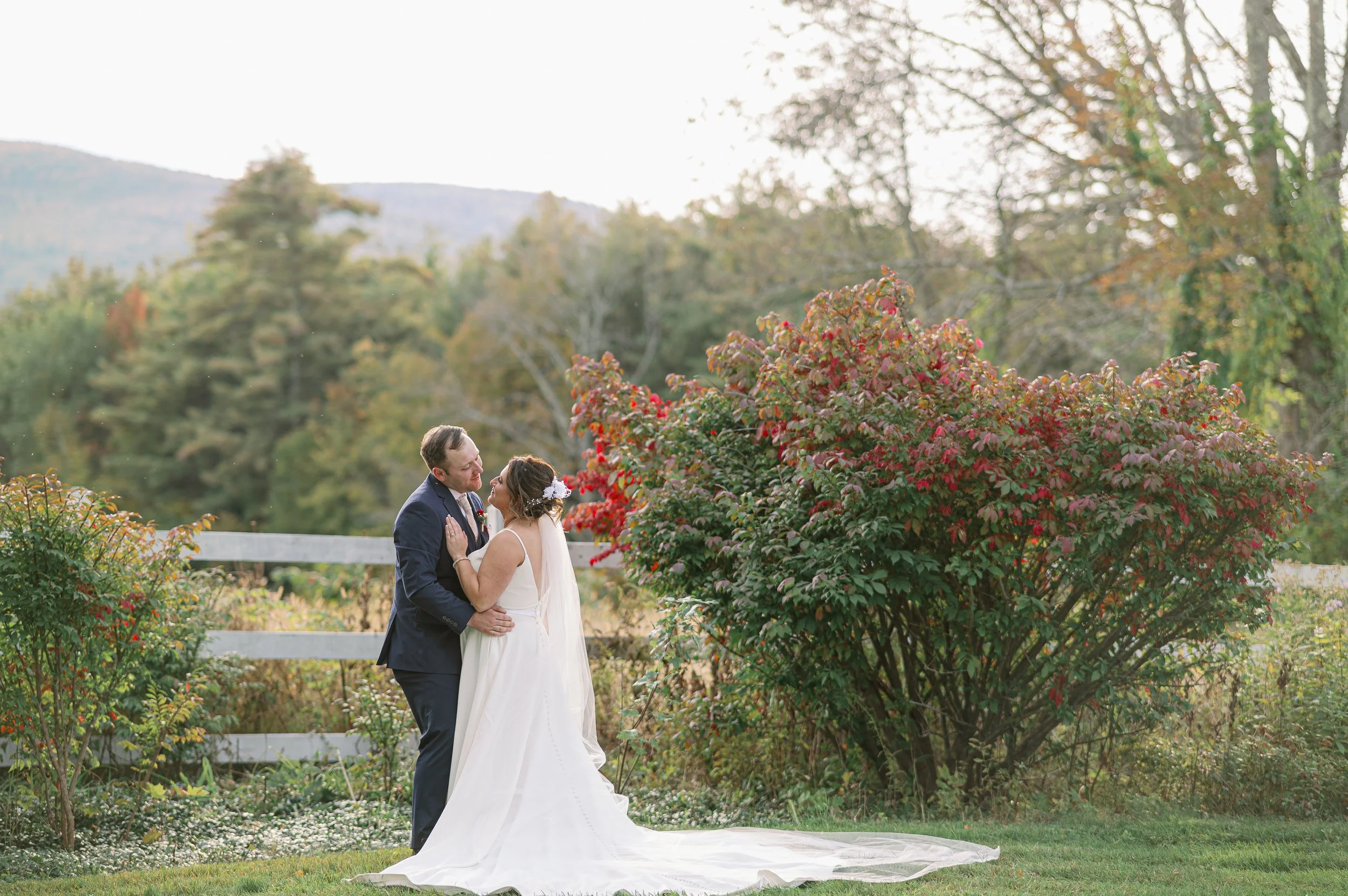 Bride and groom at their wedding portrait session in Littleton, NH surrounded by beautiful foliage.