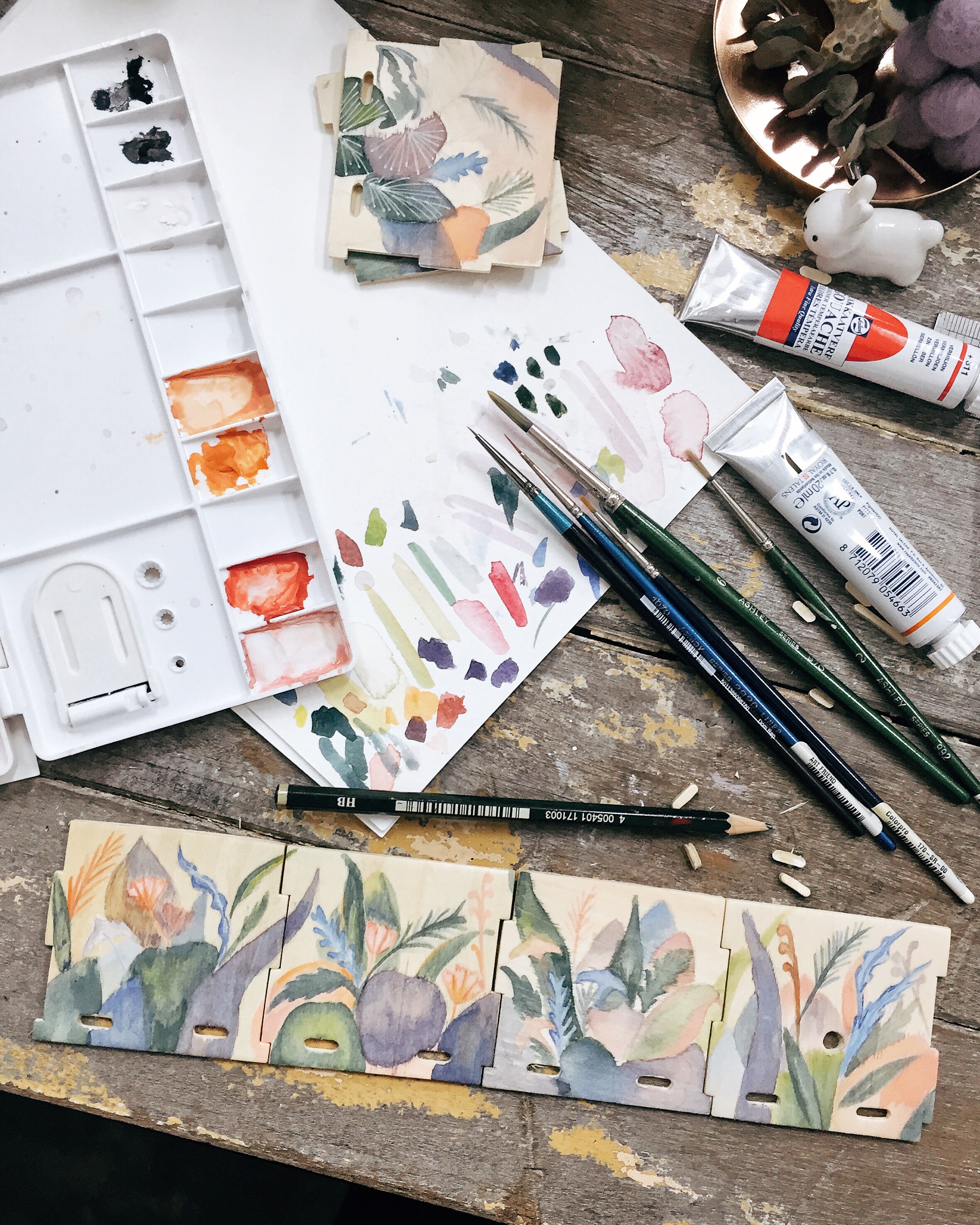 A rare photo of my messy work desk – experimenting with gouache on wood.
