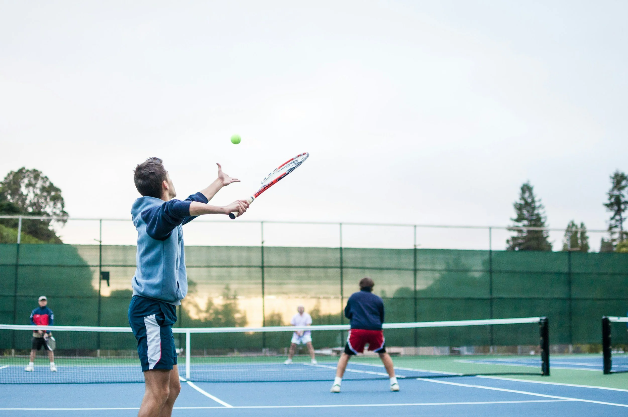 A male tennis player preparing to serve on a court