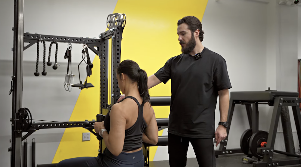 Coach Mark DiSalvo coaching Nutrition Coach Bianca Franqui through a seated neutral grip row at DiSalvo Performance Training