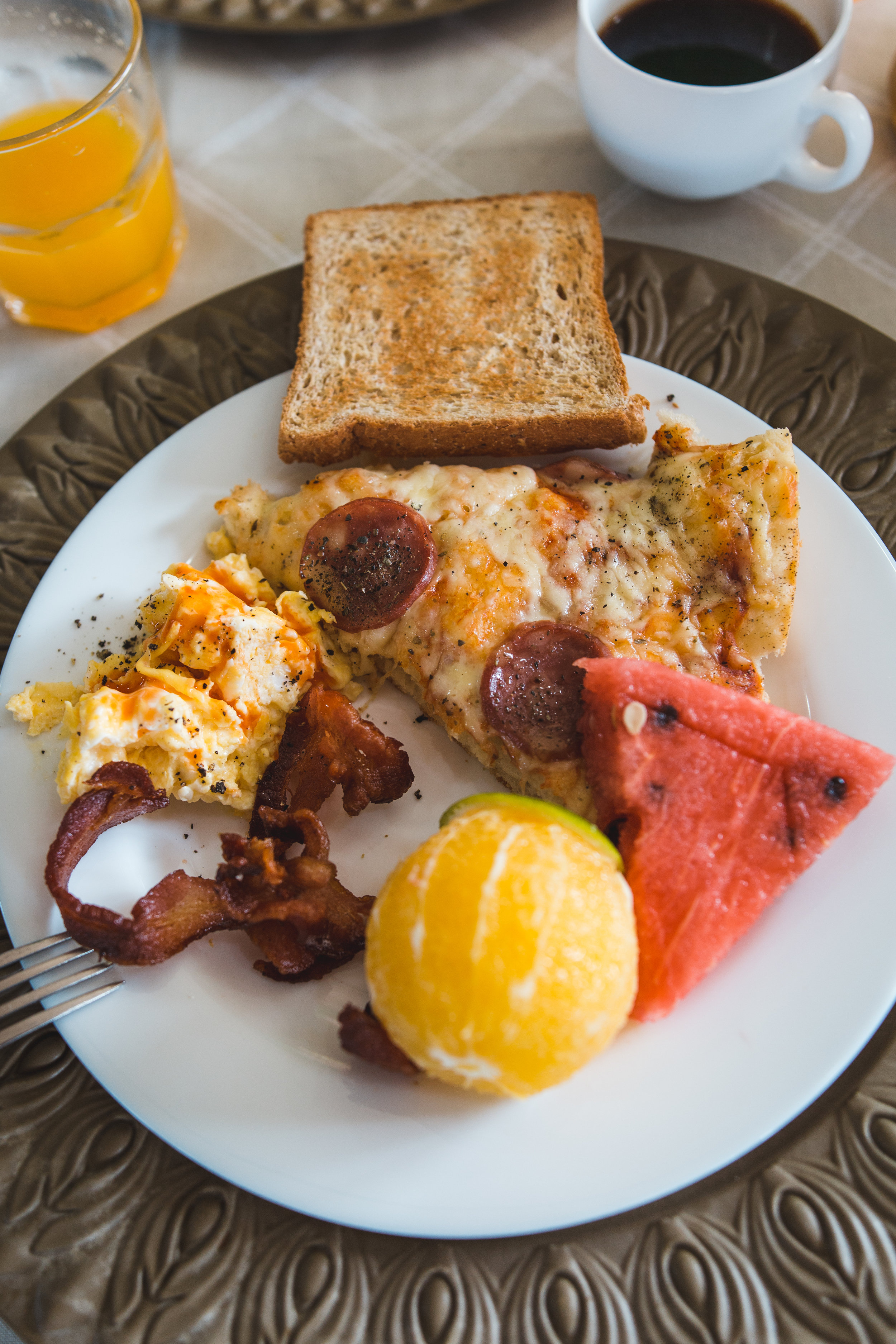  A typical breakfast, with fresh fruit, bacon, breakfast pizza, eggs, and the best coffee and juice on can drink! 