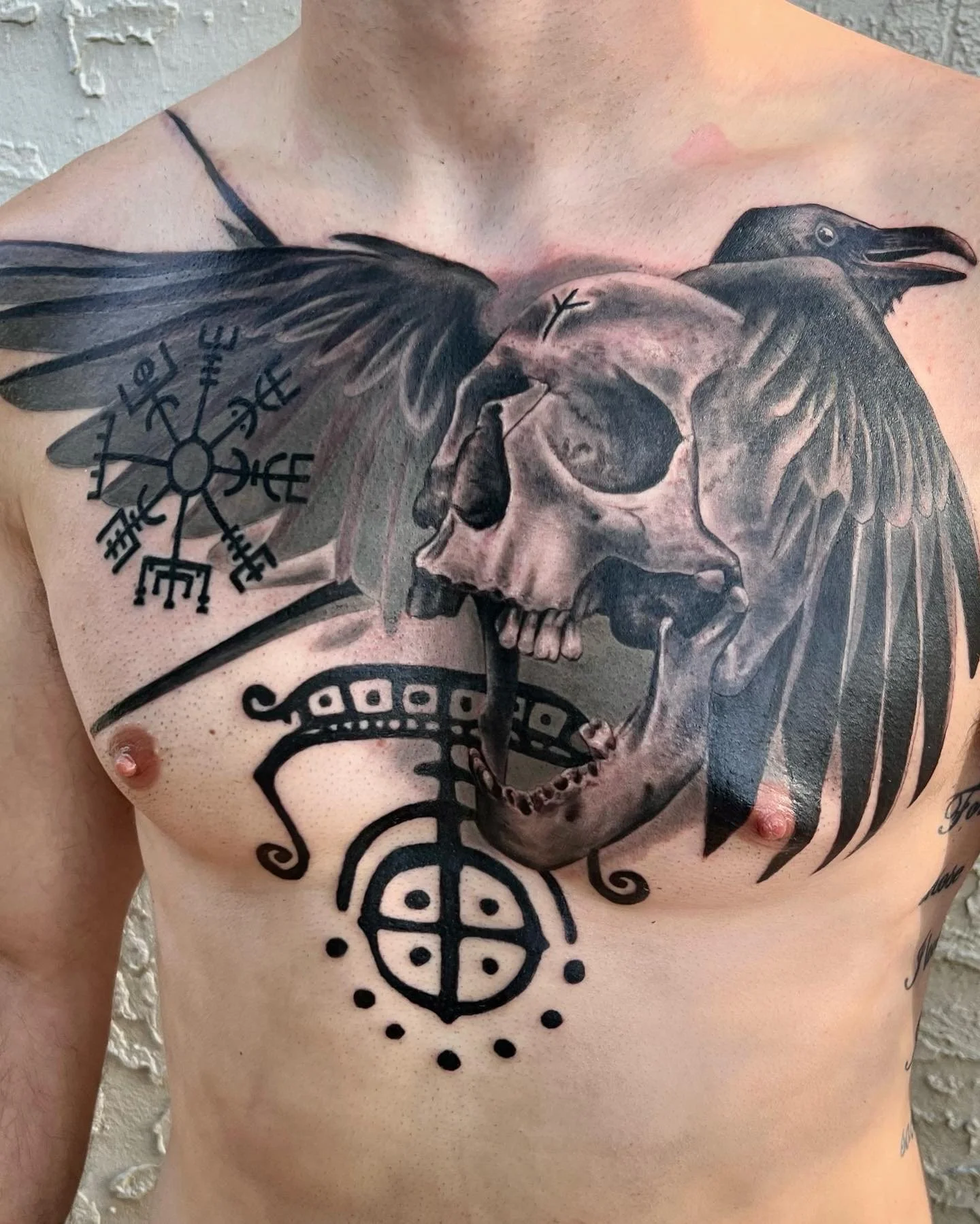 Black and grey raven and skull chest tattoo with Norse symbols, Austin, by Andrew Matela