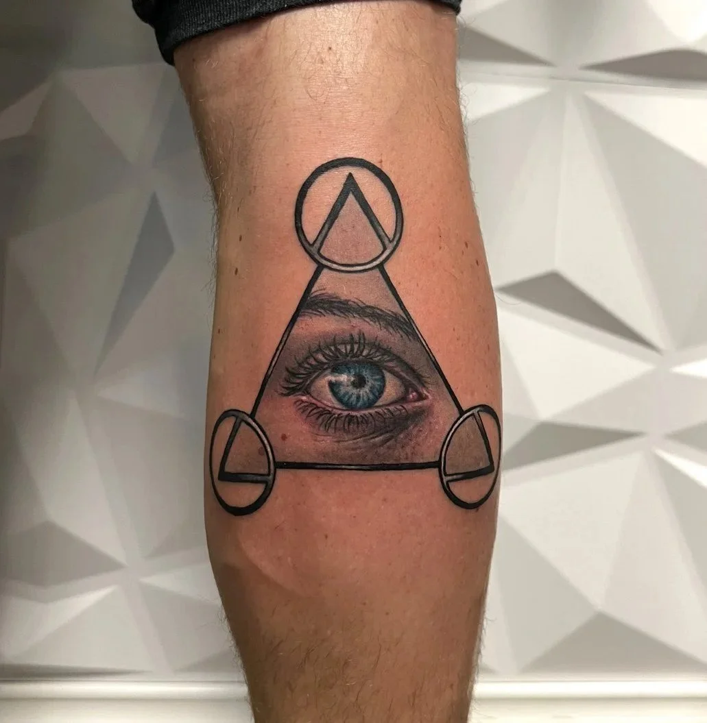 Geometric eye and triangle tattoo with cosmic symbolism by Austin tattoo artist Andrew Matela