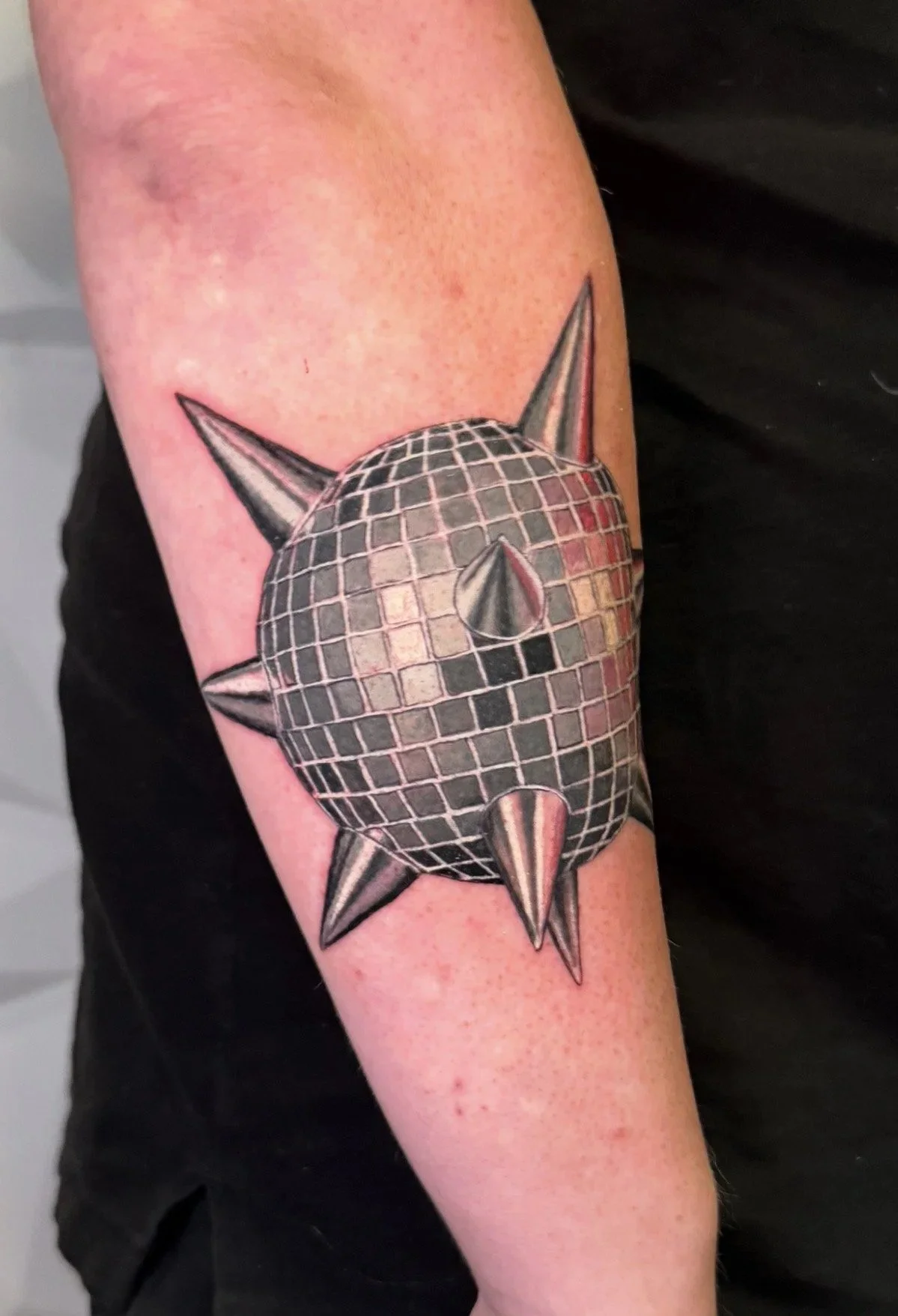 Reflective disco ball tattoo with cosmic geometric styling by Austin tattoo artist Andrew Matela
