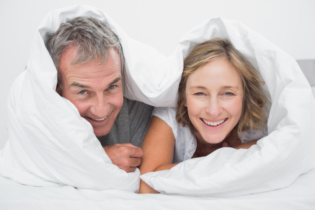 happy-middle-aged-couple-under-the-duvet_13339-20799.jpg