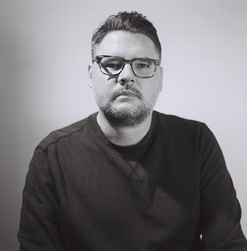 Our host and upstate correspondent is Justin Baker. Justin is a board member of Collar Works and a practicing artist who lives and works in Troy, NY. Justin teaches digital imaging and web art and design at Hudson Valley Community College. He currently lives in Troy, NY with his wife Kyra, daughters Lola and Rona, cats Lulu and Lilly.