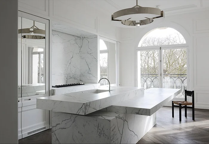 Stunning double glass doors overlooking an ornate marble kitchen island bench and copper pendant.